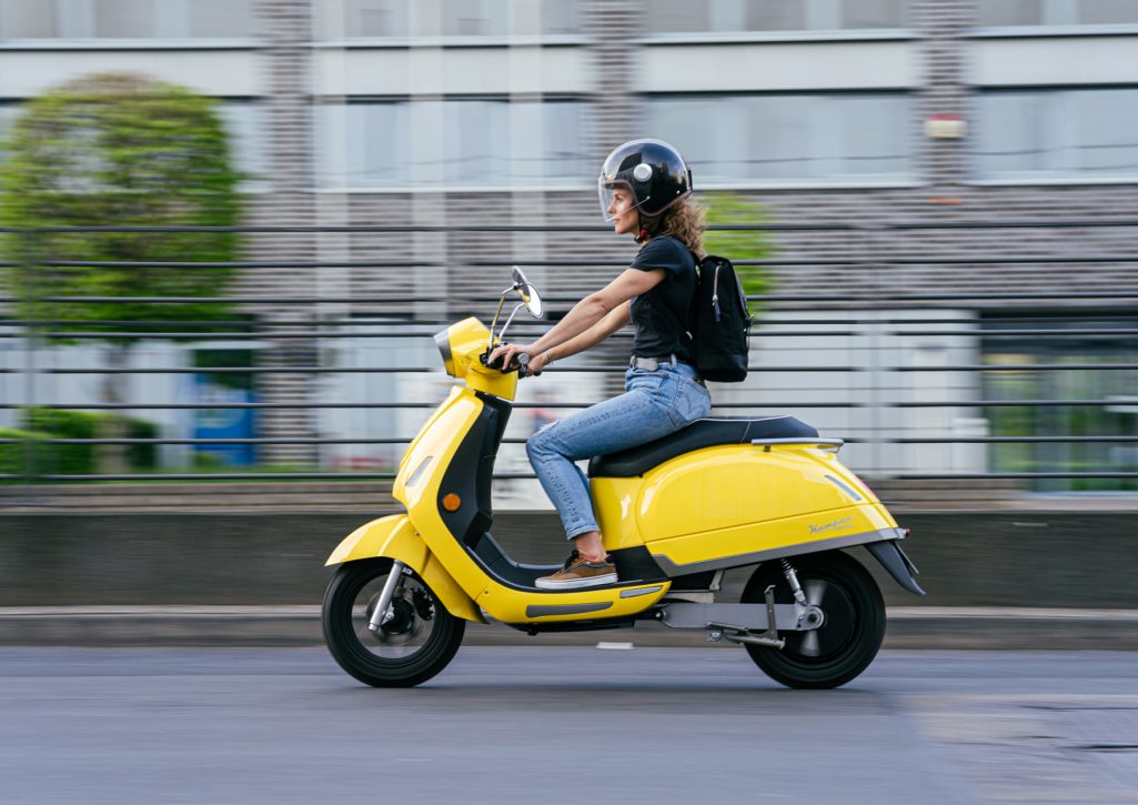 Elektroroller Moped in gelb von Kumpan mit junger Frau 